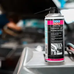 Puszka preparatu do czyszczenia wtryskiwaczy diesel marki Liqui Moly na tle silnika samochodu.