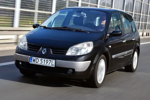 Czarny Renault Scenic 2 1.6 16v jedzie autostradą. Kierowca w okularach przeciwsłonecznych prowadzi auto.