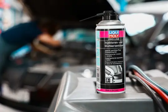 Puszka preparatu do czyszczenia wtryskiwaczy diesel marki Liqui Moly na tle silnika samochodu.