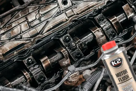 Zanieczyszczony silnik diesla i butelka K2 Motor Flush – najlepsza płukanka do silnika diesla, która przywróci mu czystość i moc.