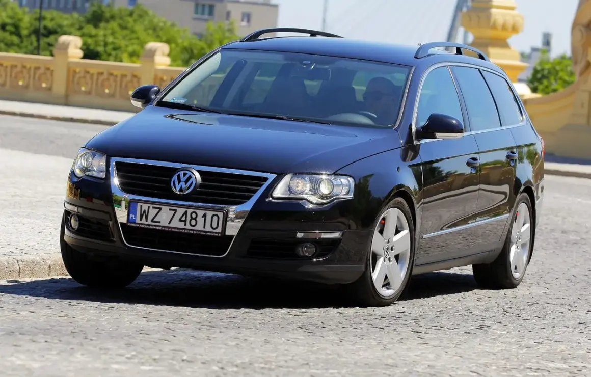 Czarny Passat B6 2.0 TDI 140KM na polskich tablicach WZ 74810, porusza się po brukowanej drodze.
